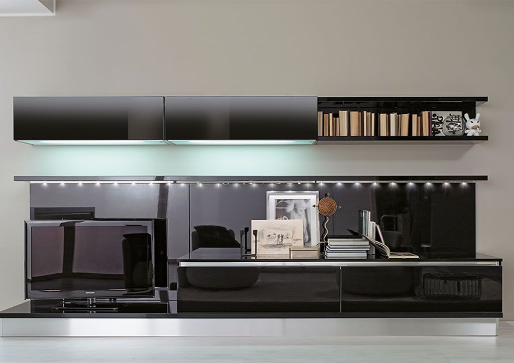 Un soggiorno con una TV e uno scaffale con dei libri sopra