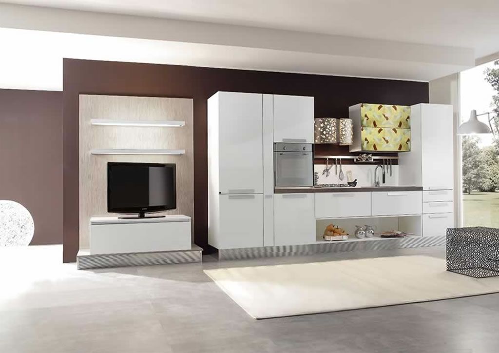 Una cucina con mobili bianchi e una TV a schermo piatto