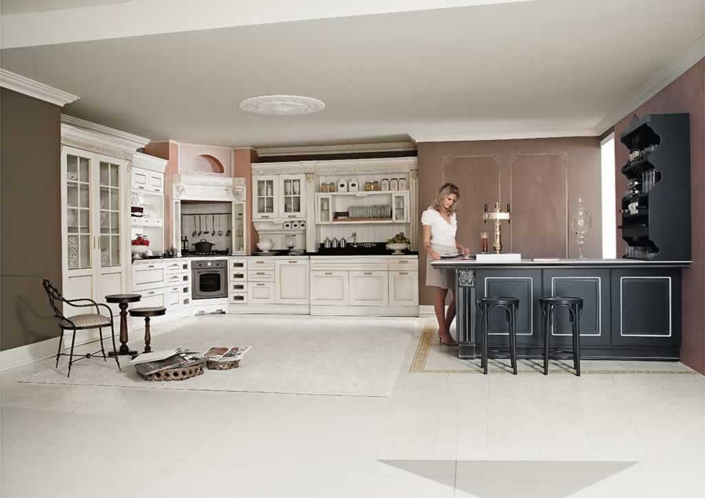 Una donna è in piedi in una cucina con mobili bianchi