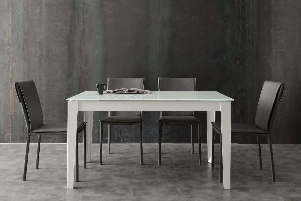 Un tavolo da pranzo con quattro sedie di fronte a una parete nera.