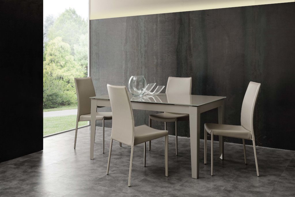 Una sala da pranzo con tavolo, sedie e una finestra