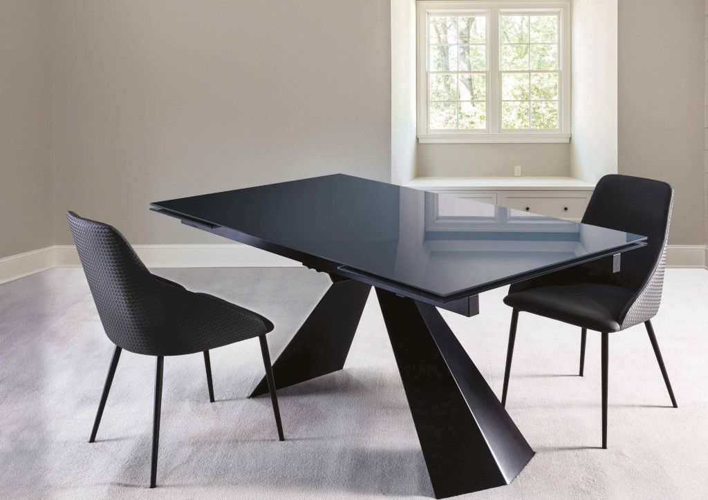 Un tavolo da pranzo nero e sedie in una stanza con una finestra.