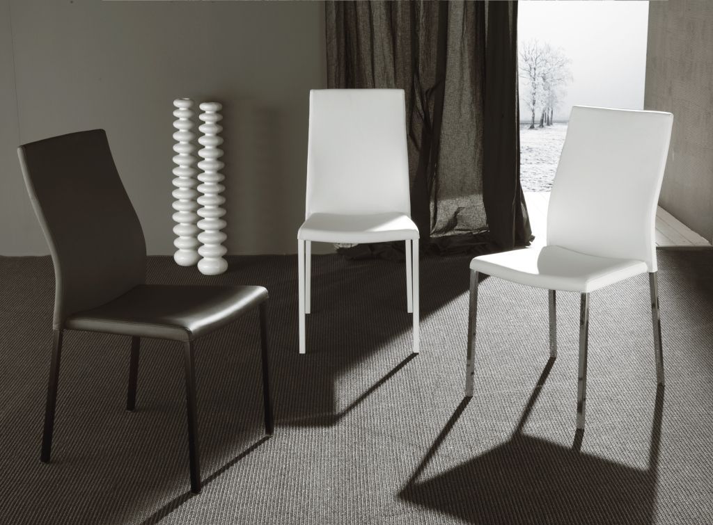 Una foto in bianco e nero di tre sedie in una stanza