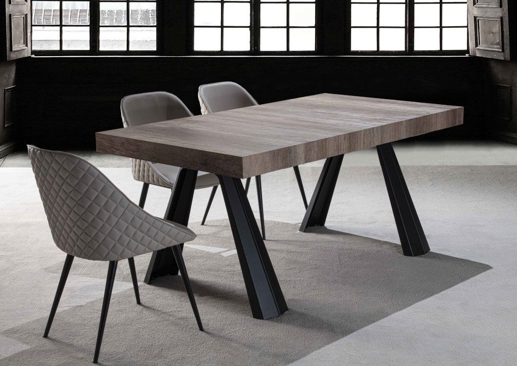 Un tavolo e delle sedie in una stanza con molte finestre