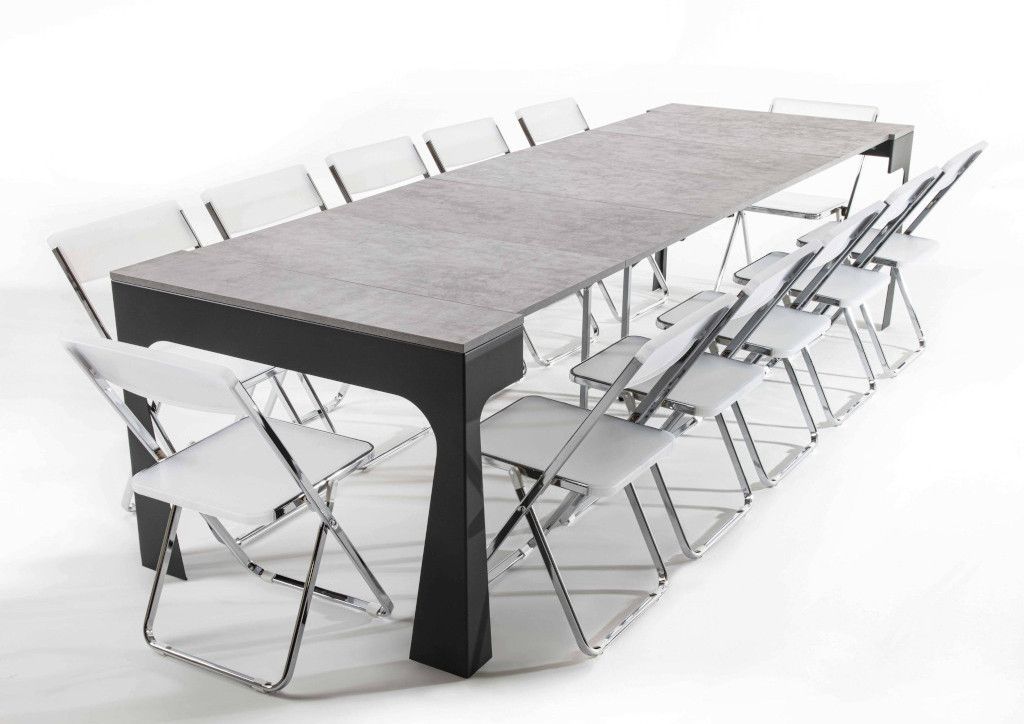 Un lungo tavolo con sedie bianche attorno ad esso su uno sfondo bianco.