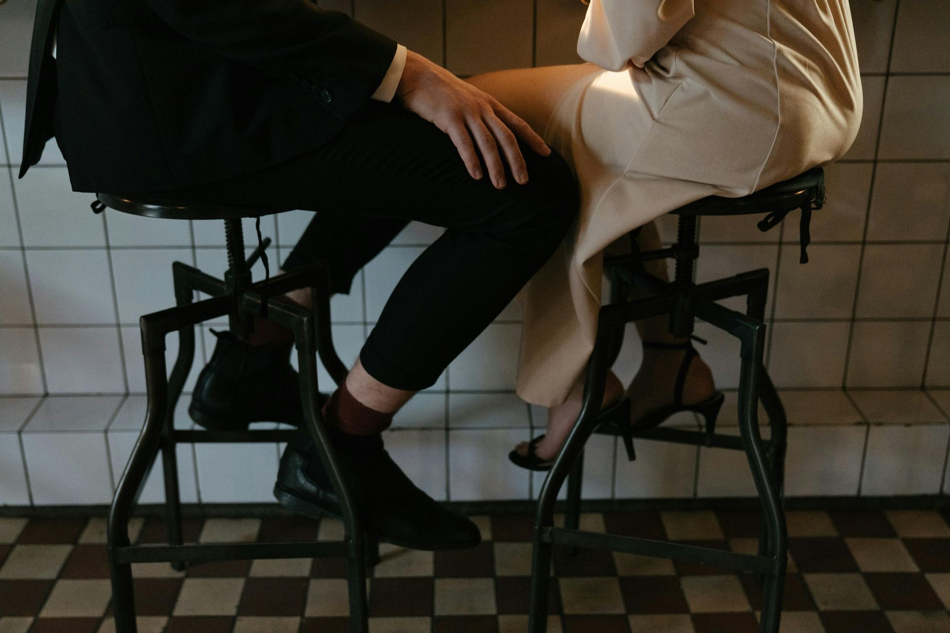 A man and a woman are sitting on a bar stool.