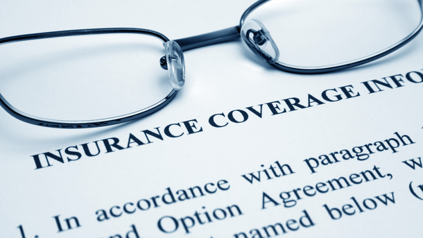 Eyeglasses on insurance coverage document.