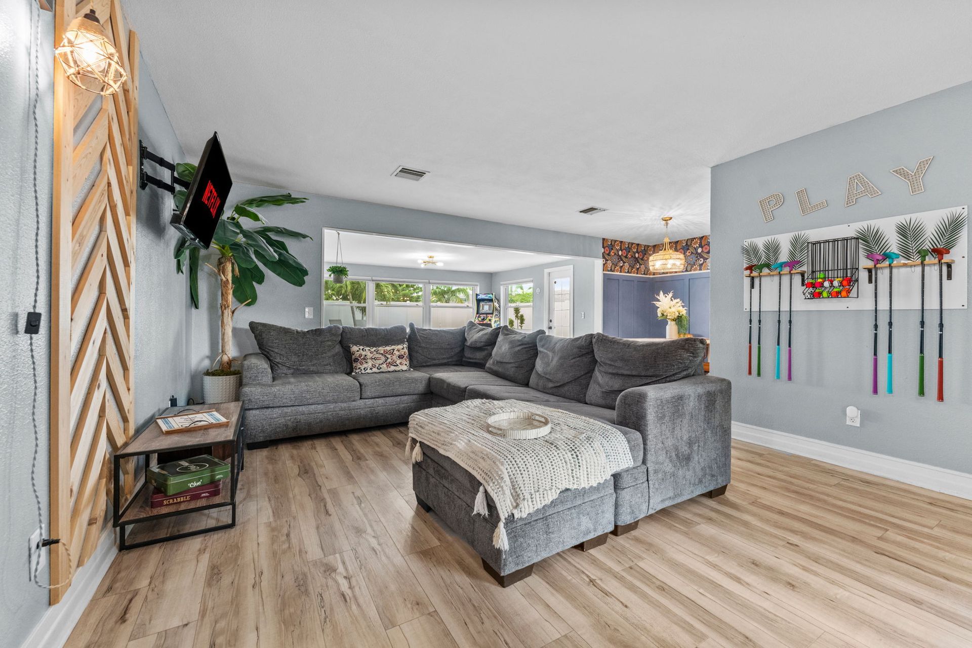Woman in straw hat smiles, holding wine glass near a lake.