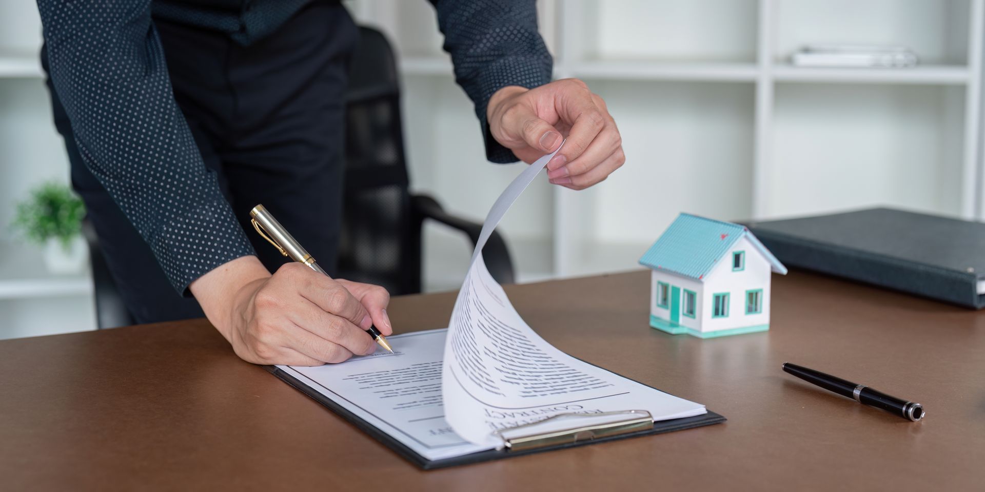 A person holding a baby up in the air indoors near a window, baby smiling.