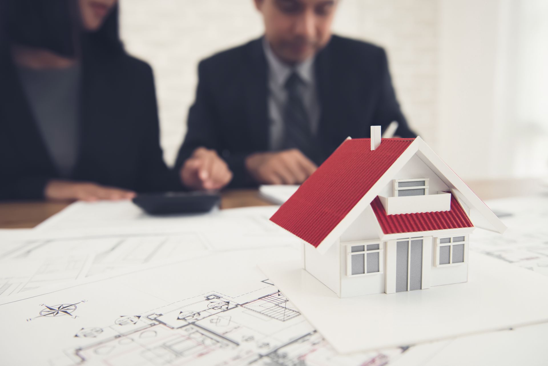 Woman in straw hat smiles, holding wine glass near a lake.