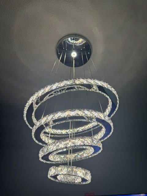 Modern spiral chandelier with crystal rings hanging from a ceiling mount