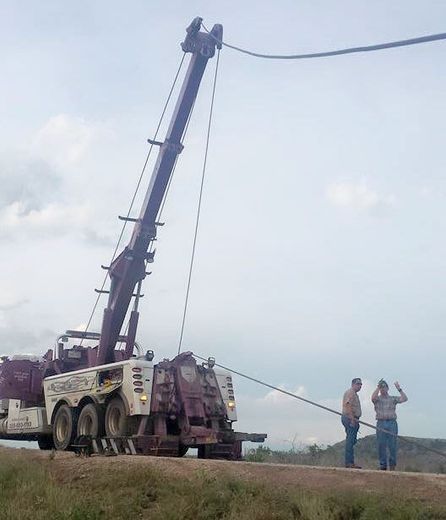 Techs hooking up towing truck to tow