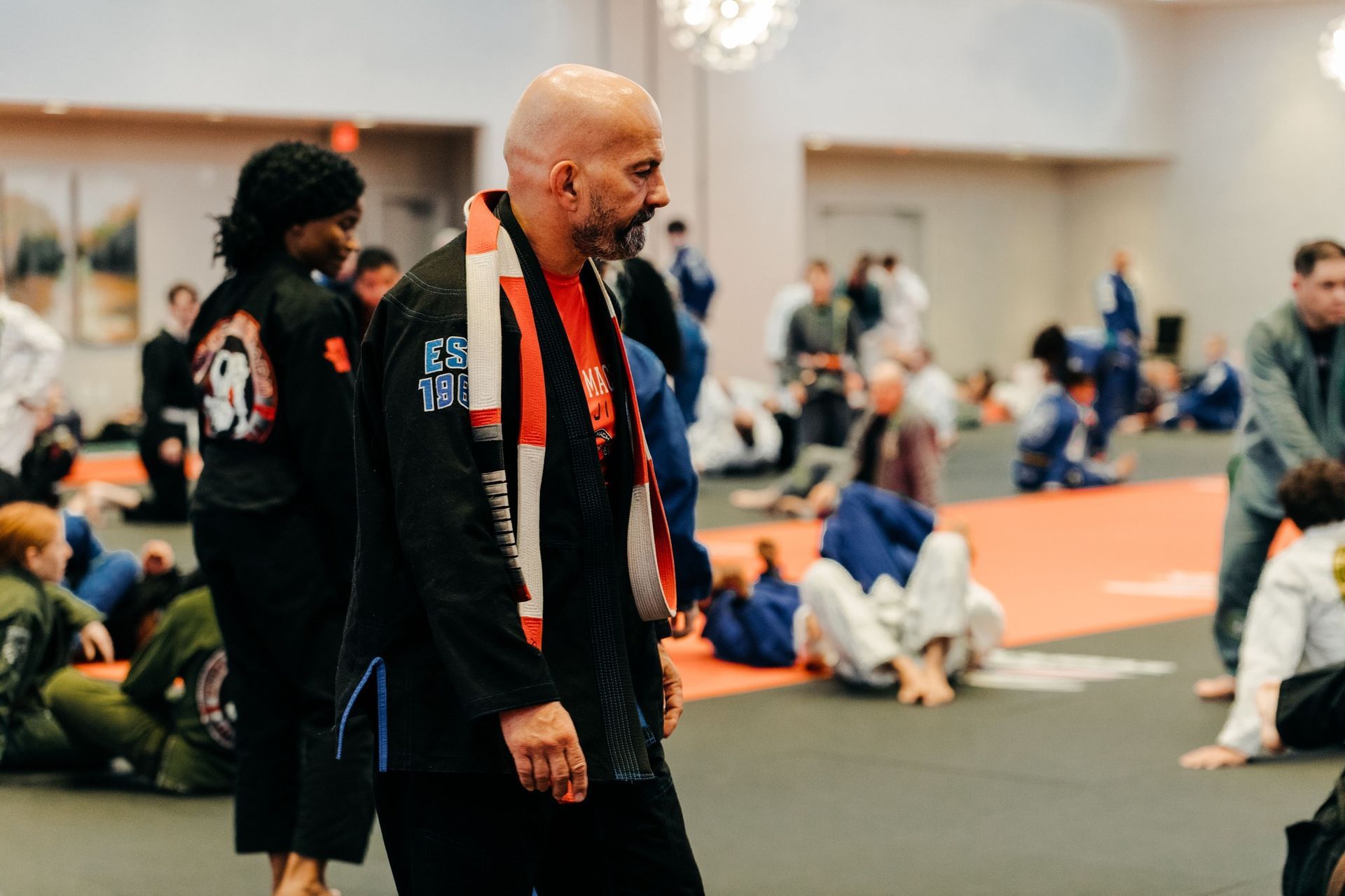 a man in a karate uniform is tying his purple belt .