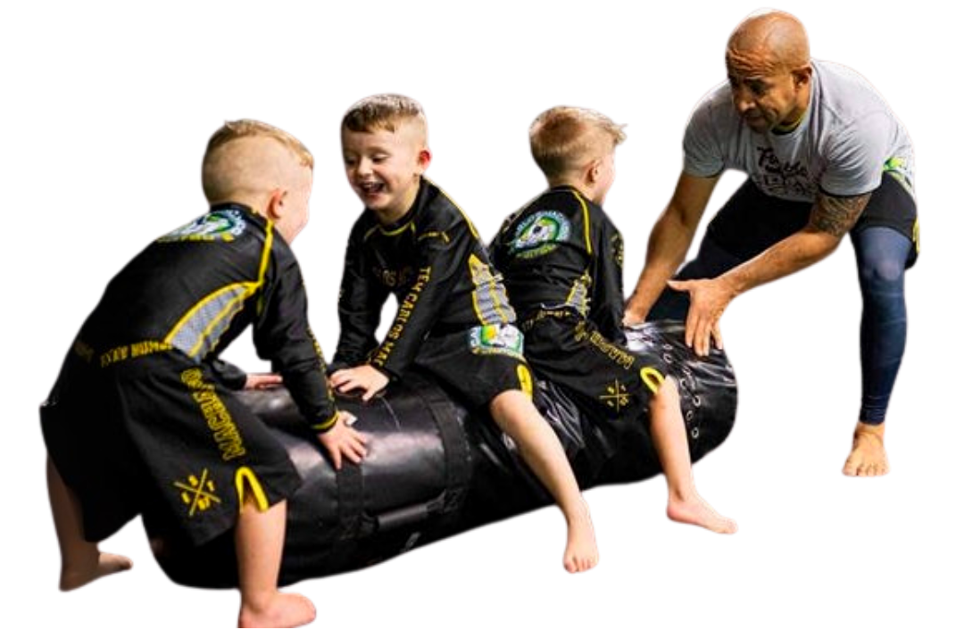 A group of kids in karate uniforms are sitting on the floor drinking water