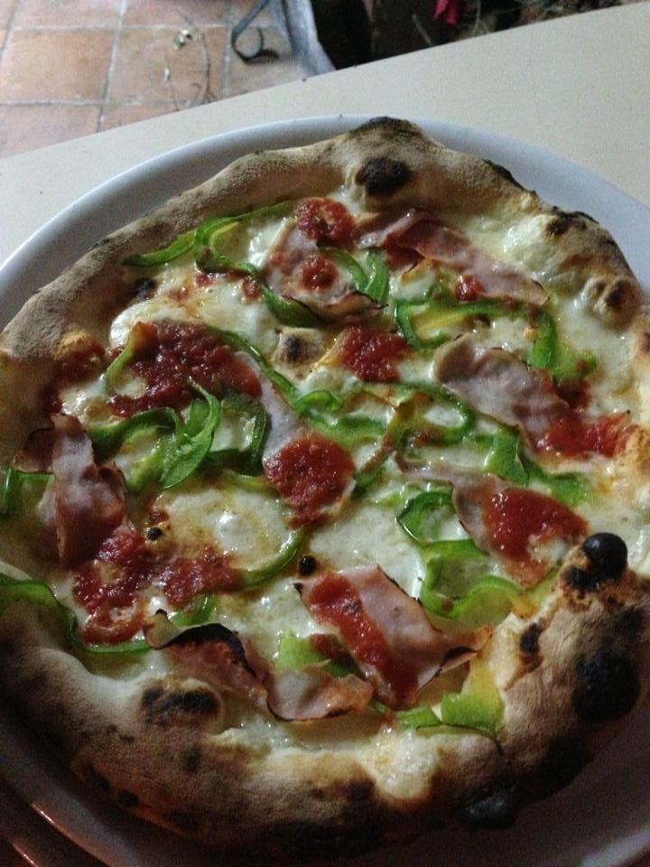 Una pizza con peperoni e formaggio su un piatto bianco