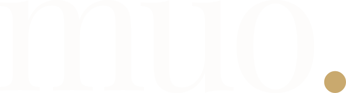 Pale background with large faint white letters and a small gold circle in the bottom-right corner