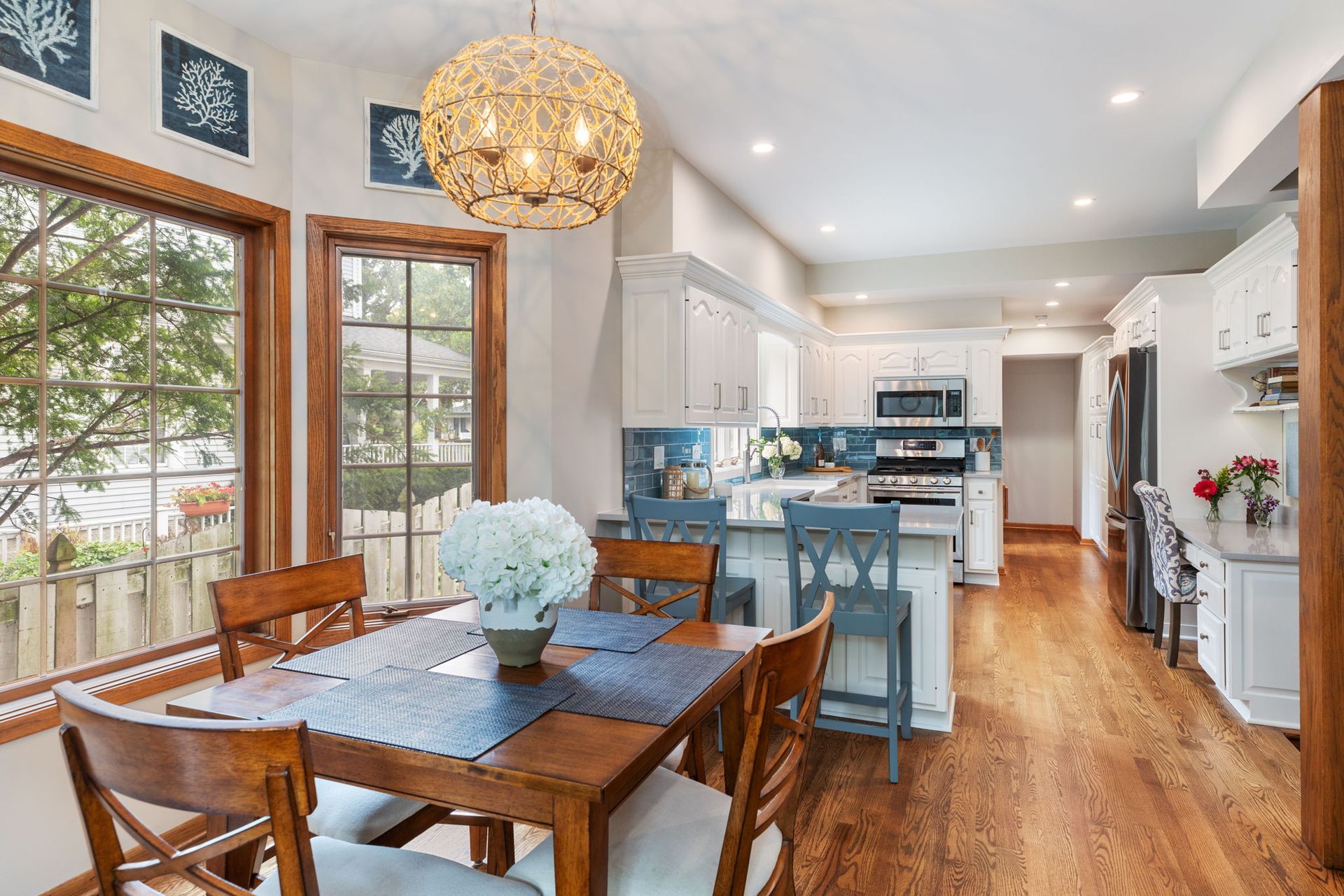 A dining room table and chairs in a kitchen with a chandelier hanging from the ceiling.