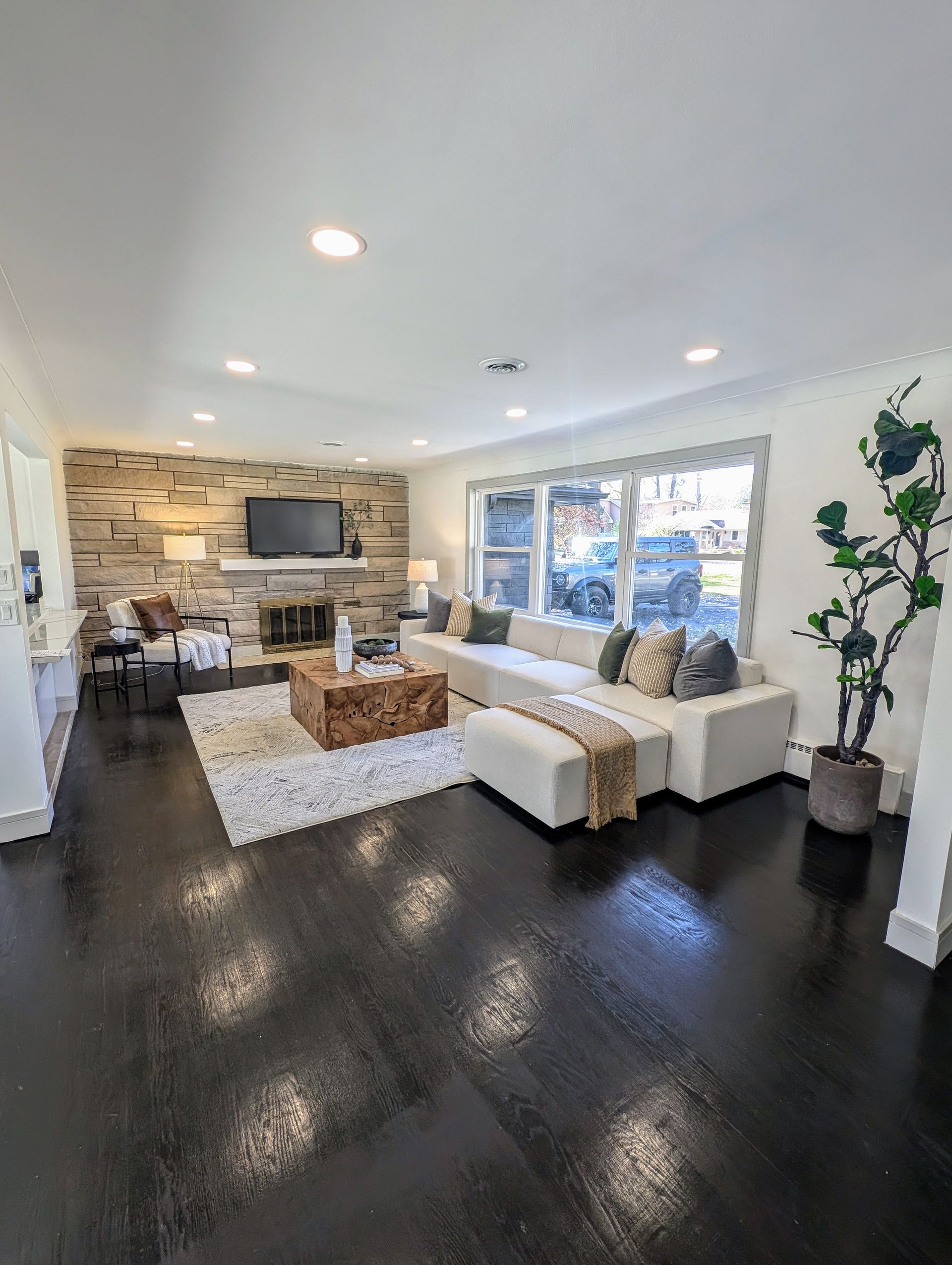 A living room with a couch , coffee table , fireplace and television.