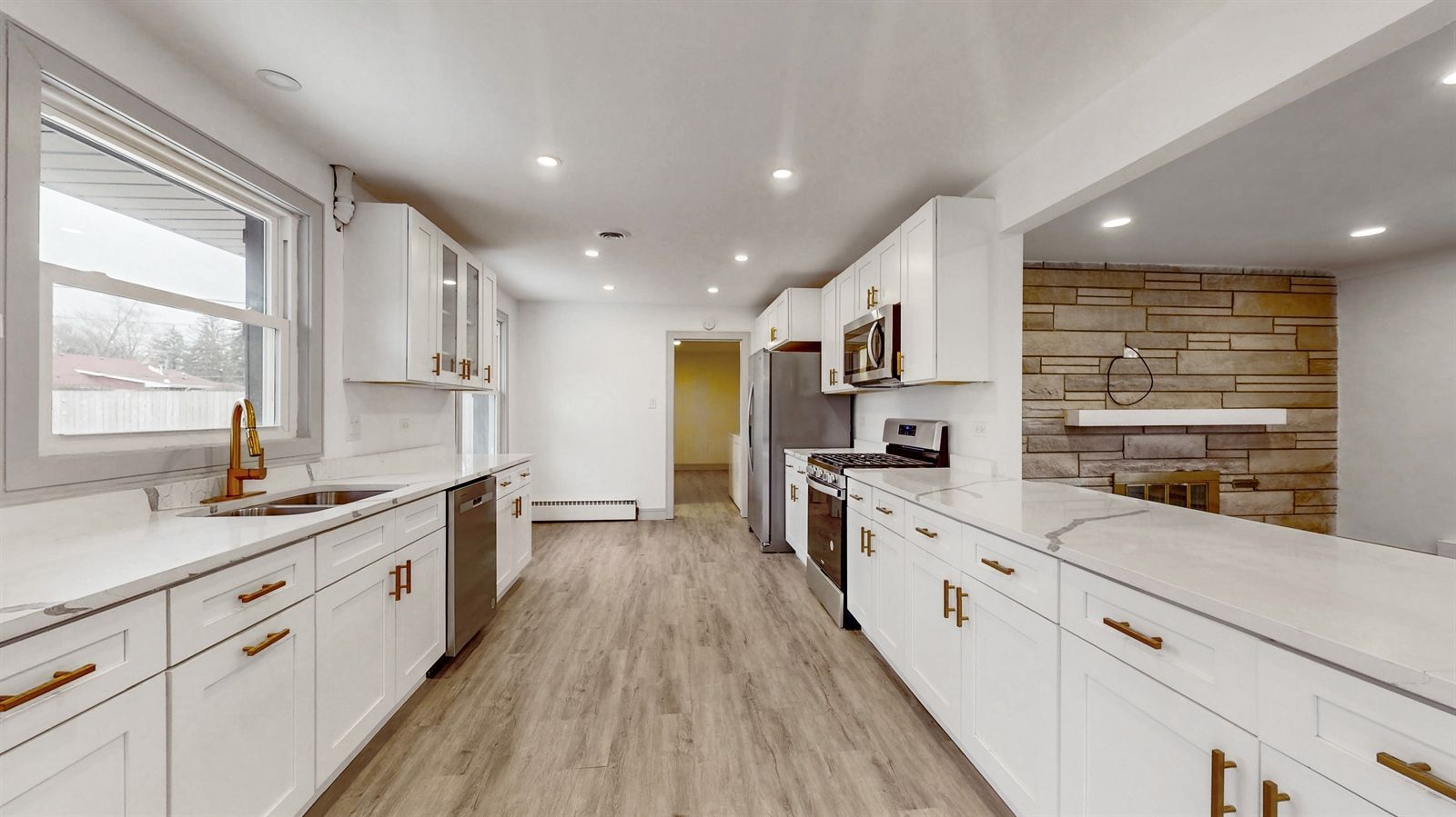 A kitchen with white cabinets , stainless steel appliances , and hardwood floors.
