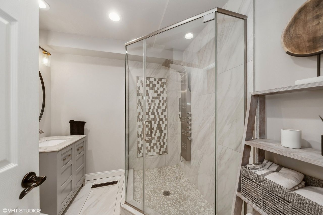 A bathroom with a walk in shower and a sink north shore