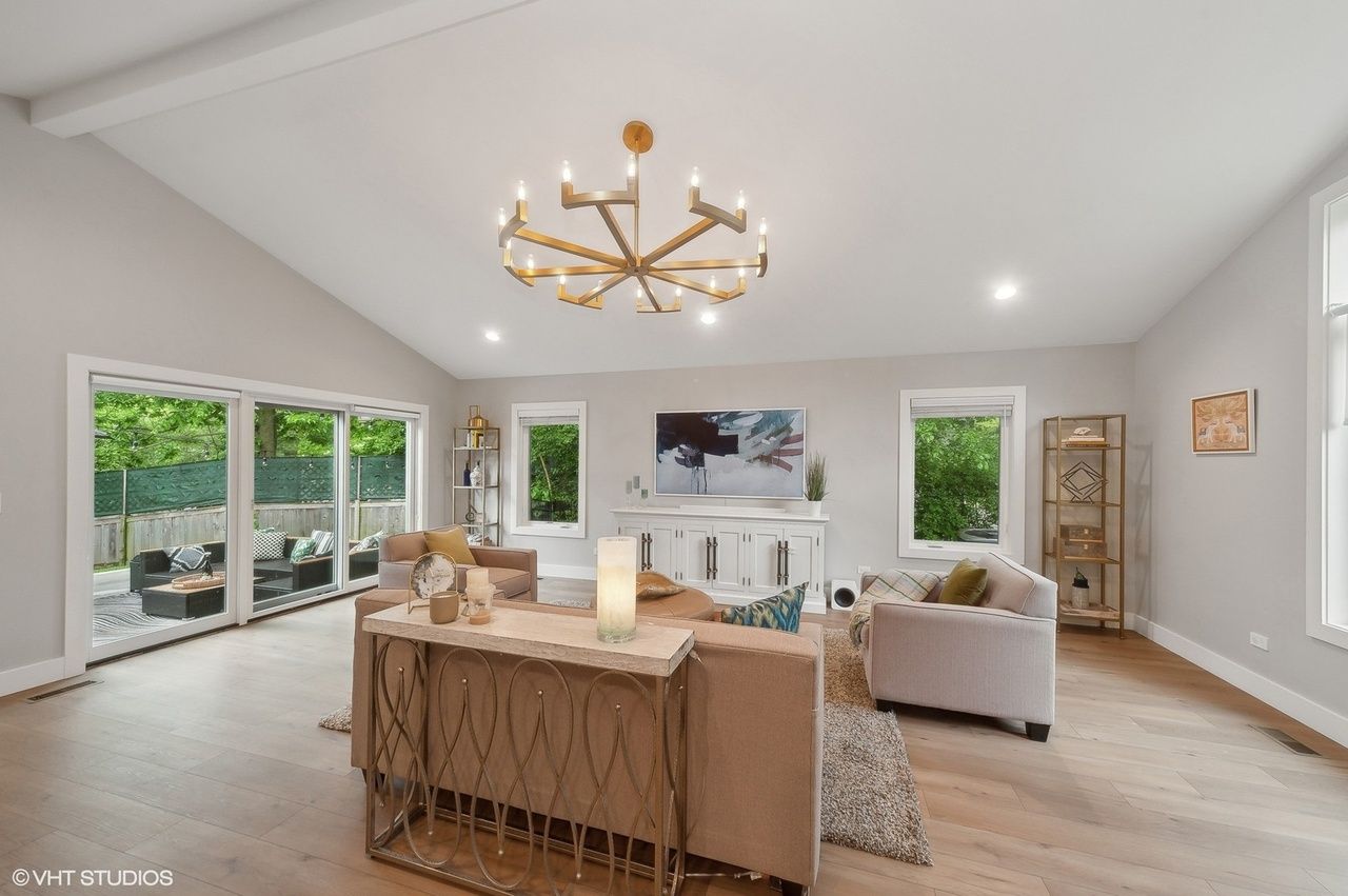 A living room with a lot of furniture and a chandelier hanging from the ceiling north shore il