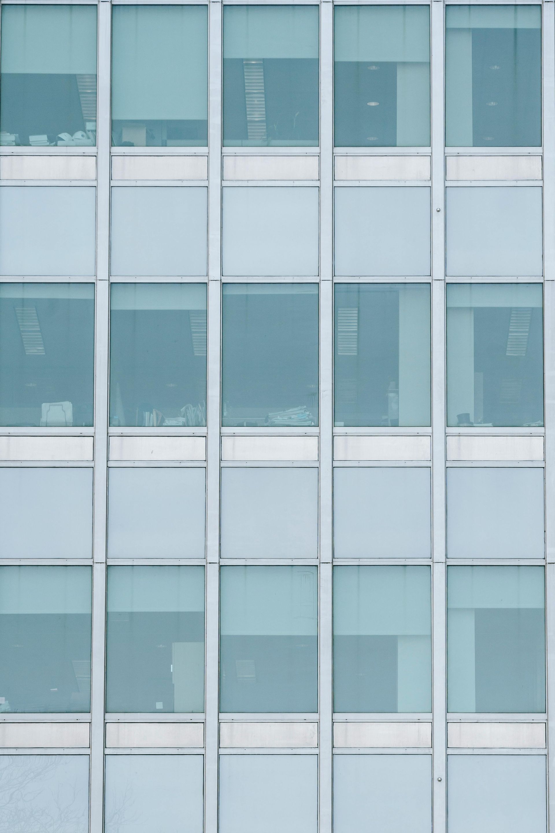 Facade of a modern building with rows of square, tinted windows.