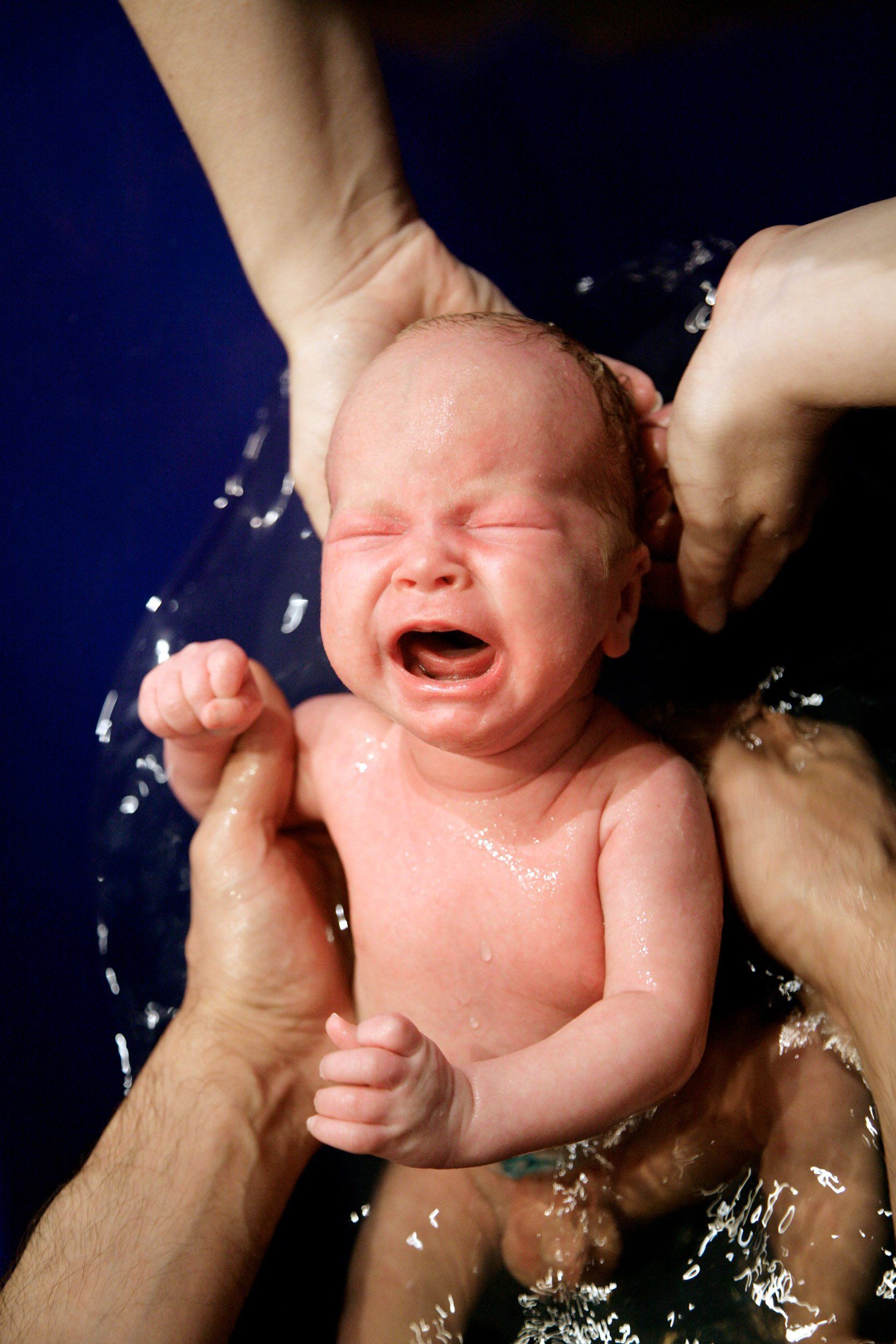 Hands of parents bathing their baby boy