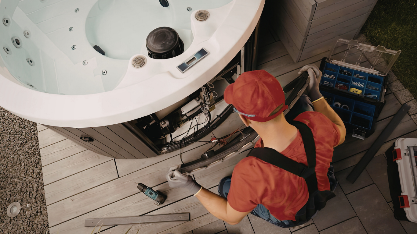 Technician in red hard hat working on a large white machine with tools in an industrial setting