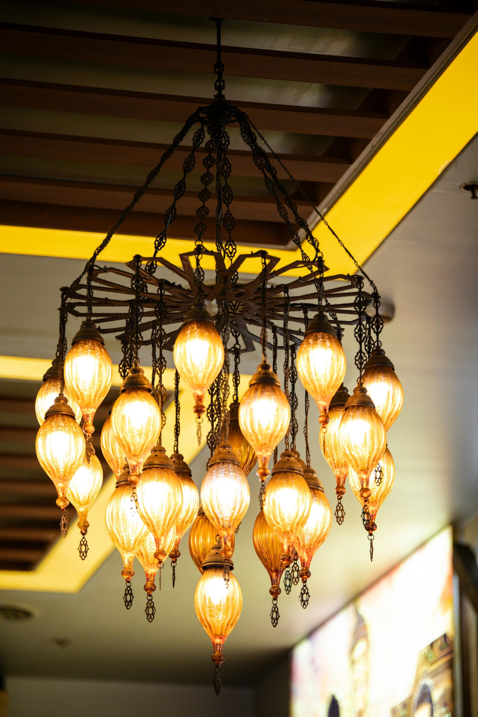 Hanging chandelier with many glowing teardrop lights in a warm indoor space