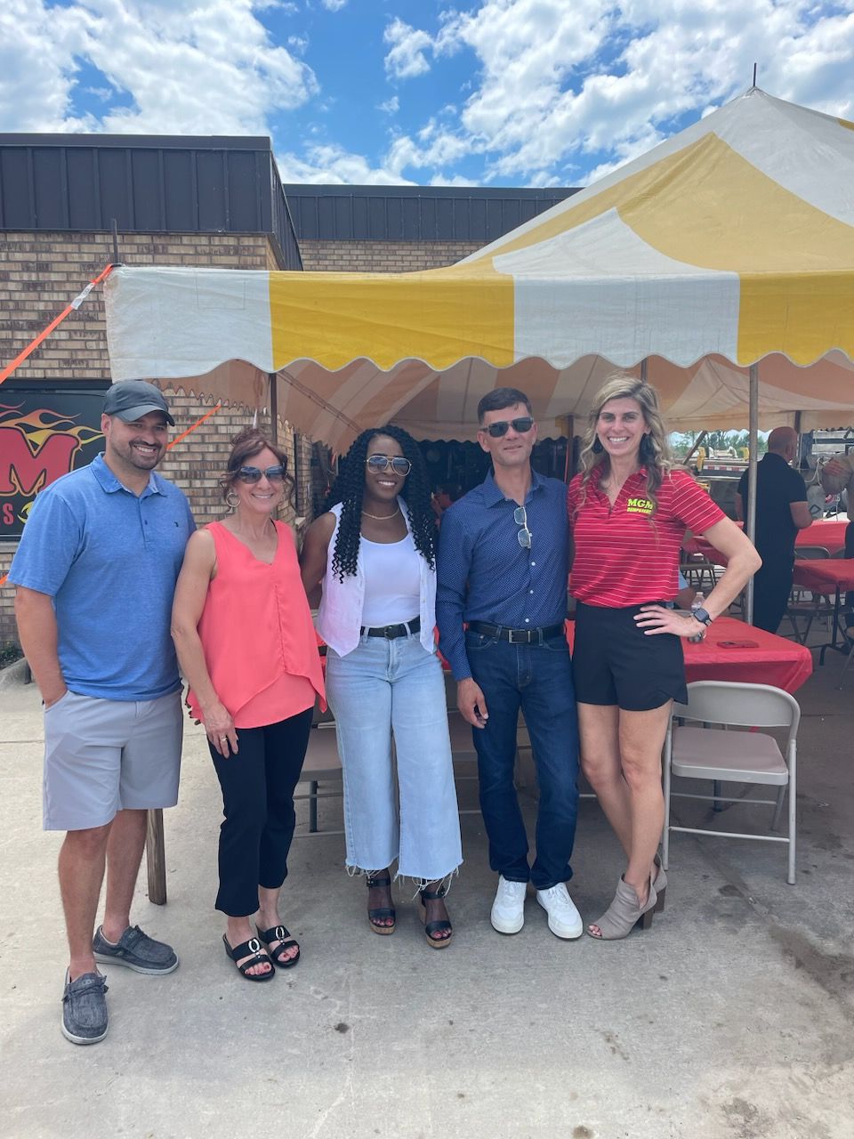 A group of people are posing for a picture in front of a tent.