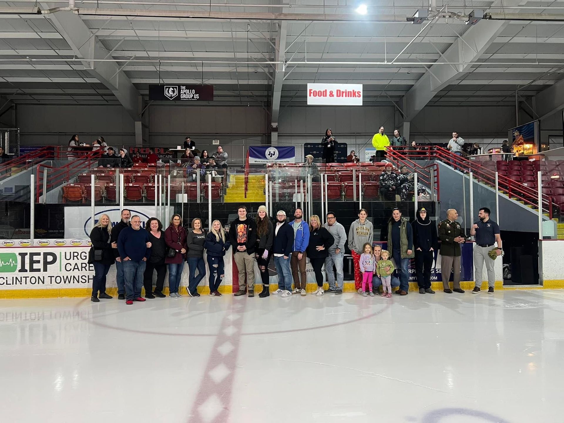 A group of people are posing for a picture on an ice rink.