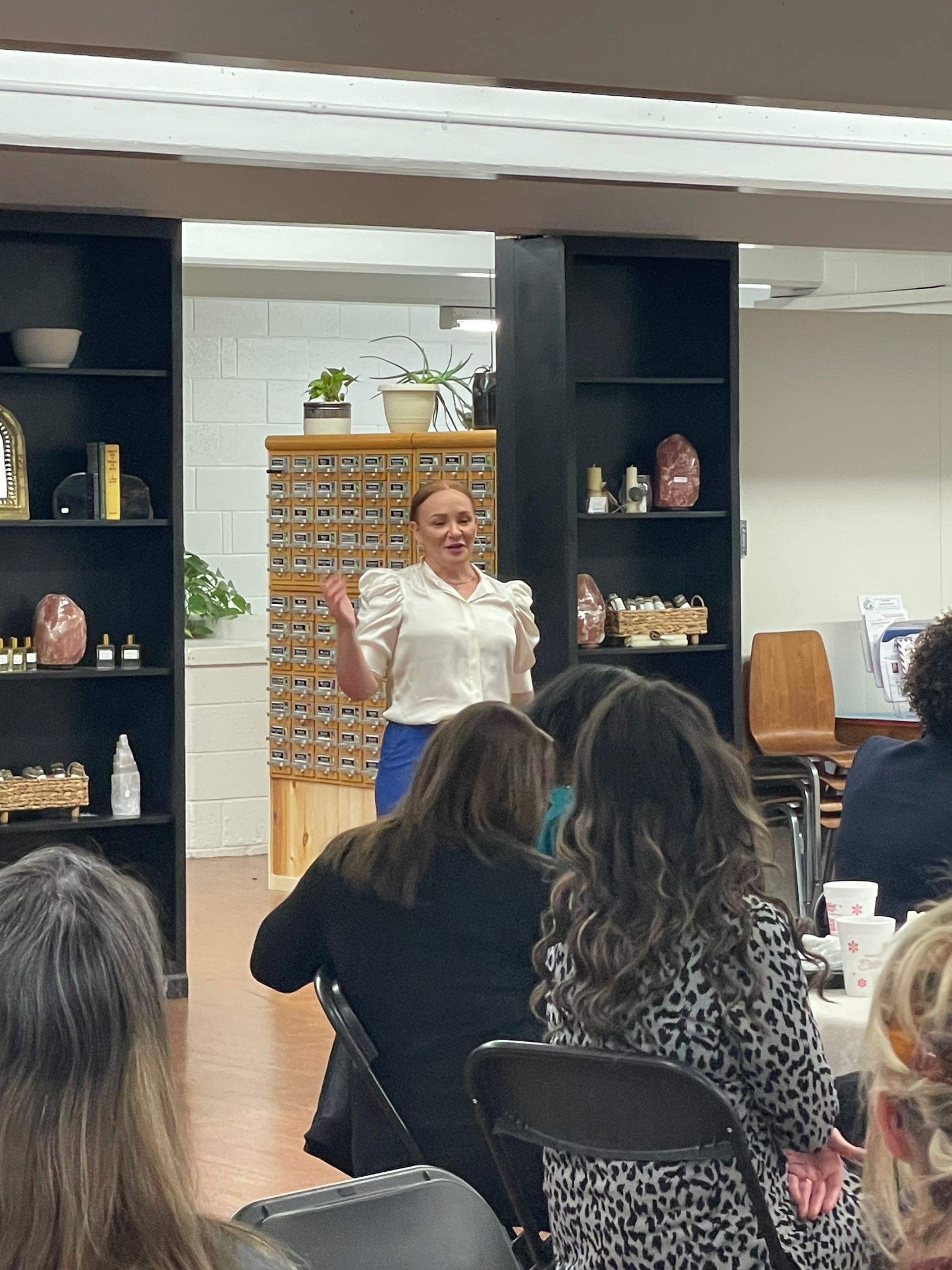 A woman is giving a presentation to a group of people in a room.