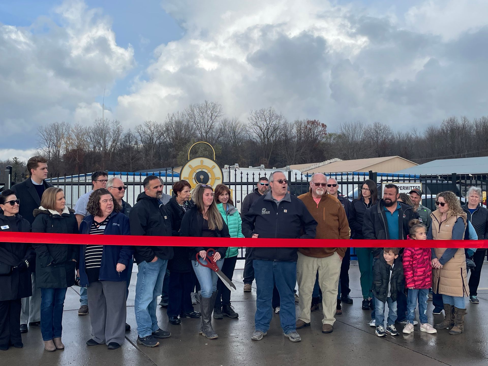 A group of people standing in front of a red ribbon.