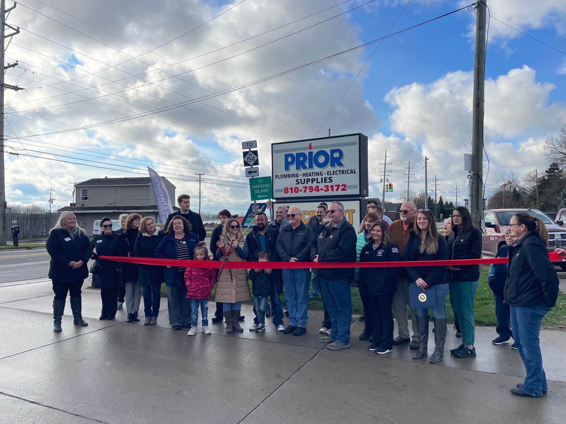 A group of people are standing in front of a sign that says prior.