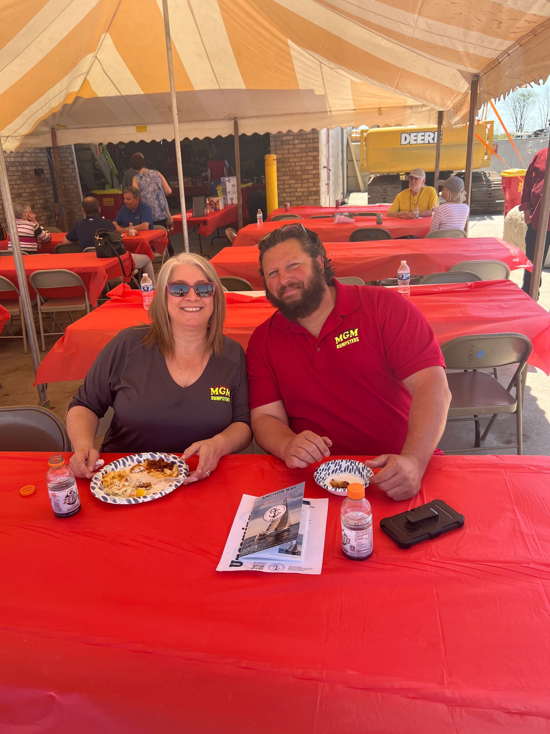 A man and a woman are sitting at a table under a tent