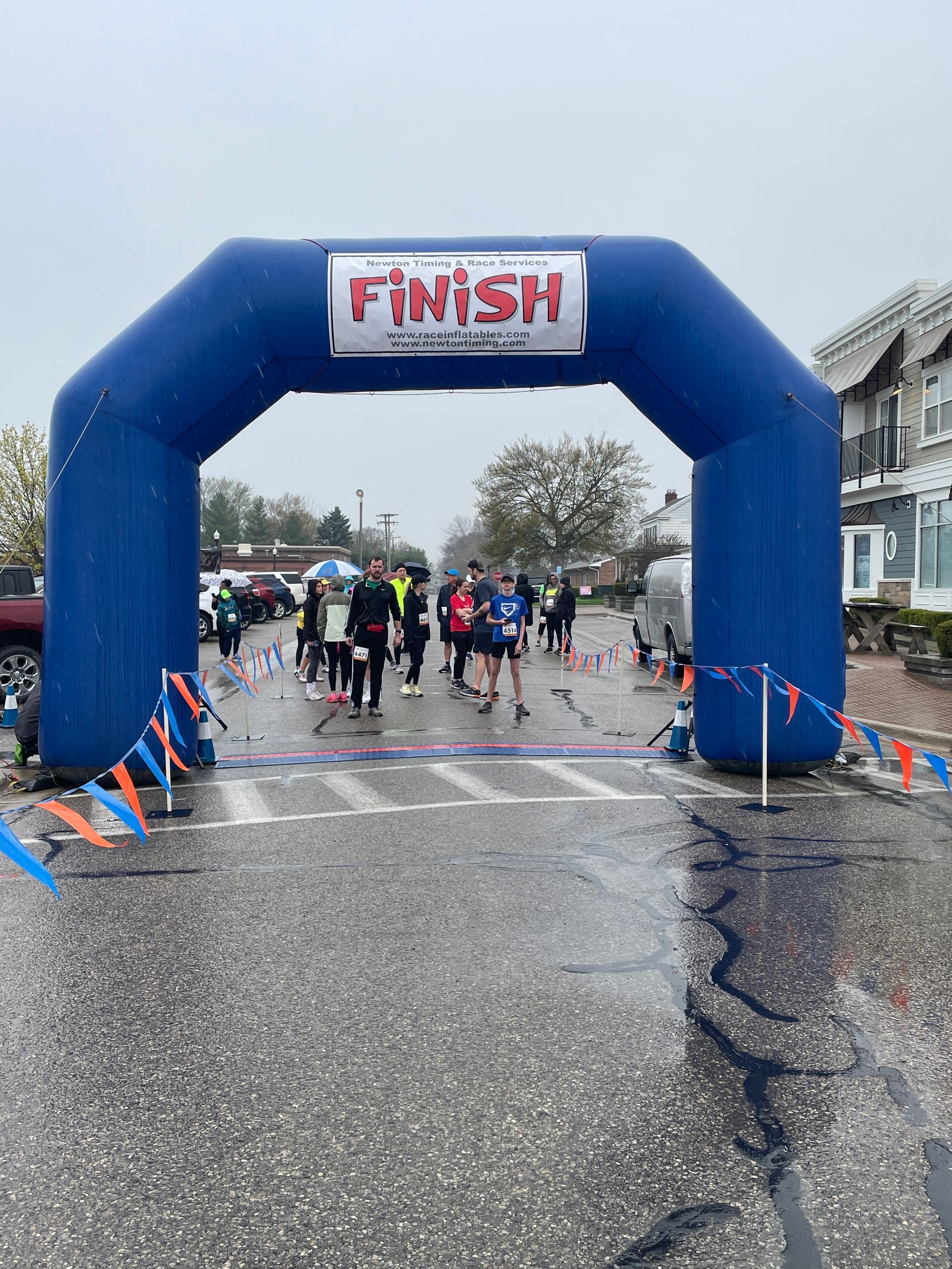 A group of people are walking under an inflatable arch that says finish.
