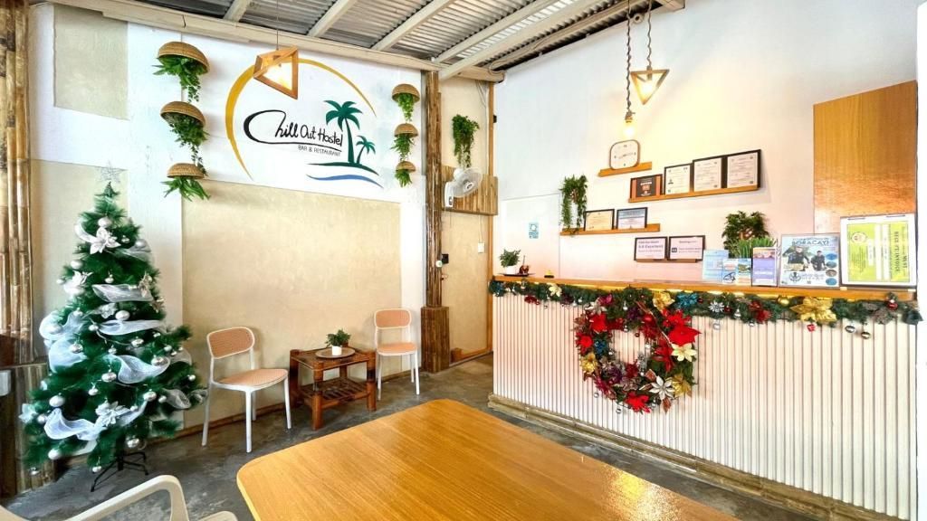 Reception area decorated for Christmas; desk, chairs, Christmas tree, sign.