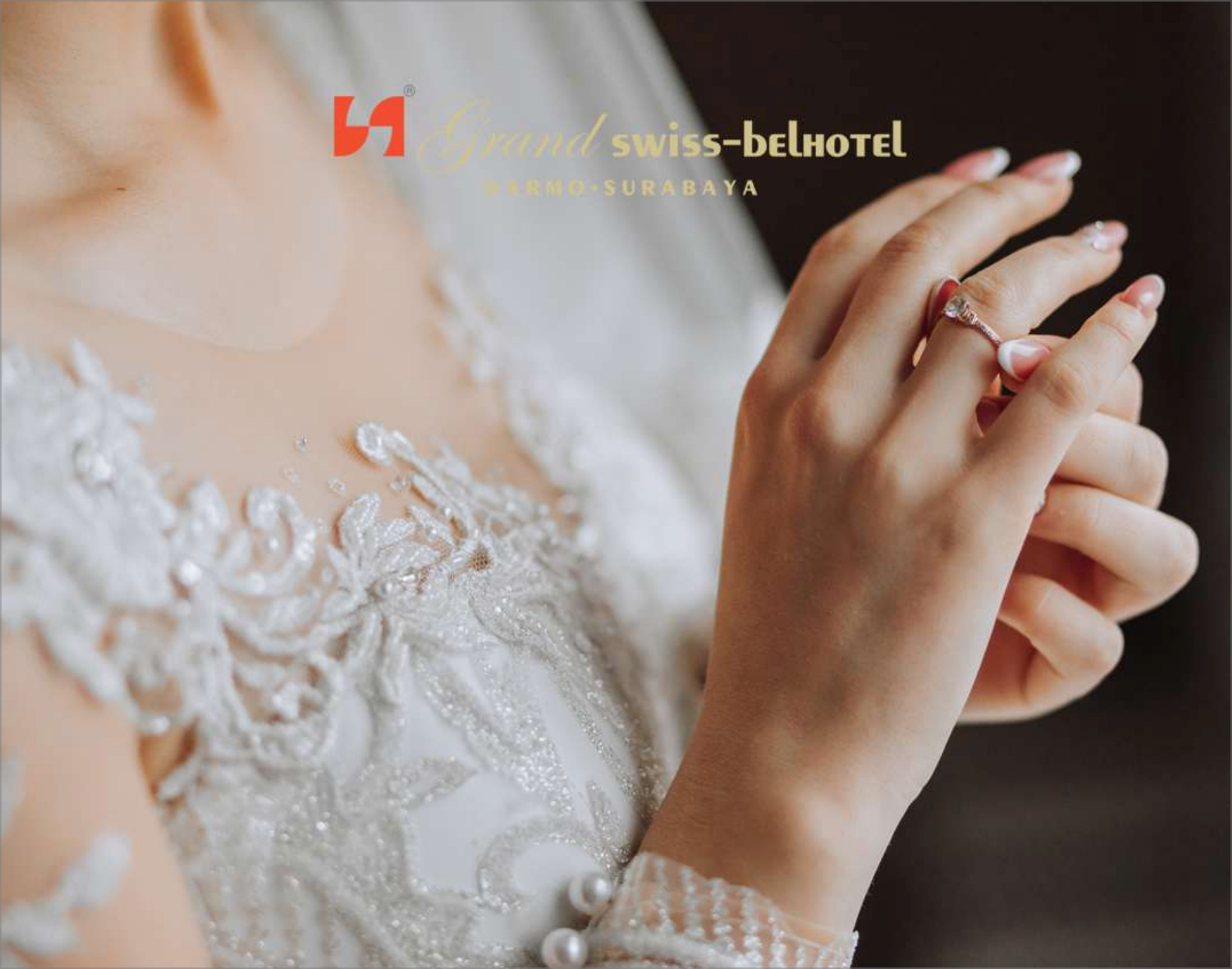 A woman in a wedding dress is putting a ring on her finger