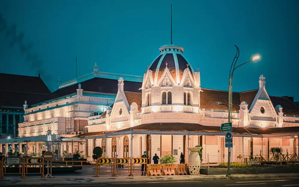 A large building with a dome on top of it is lit up at night.