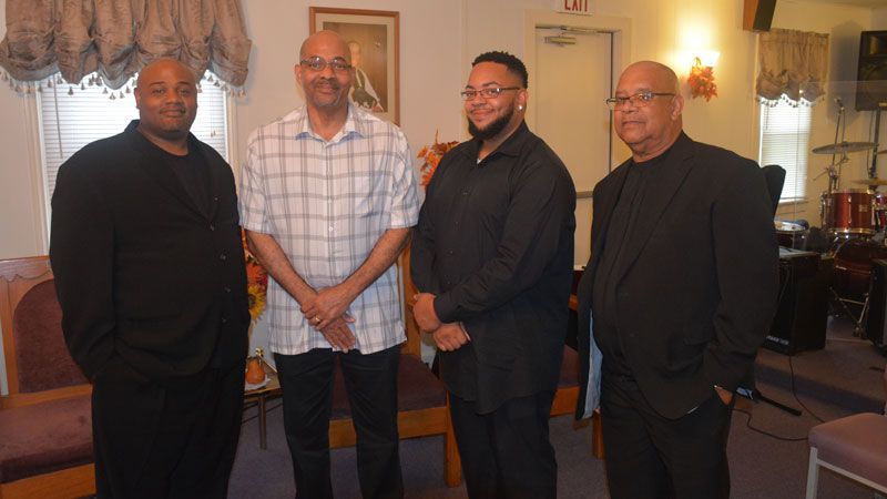 A group of men are standing next to each other in a room.