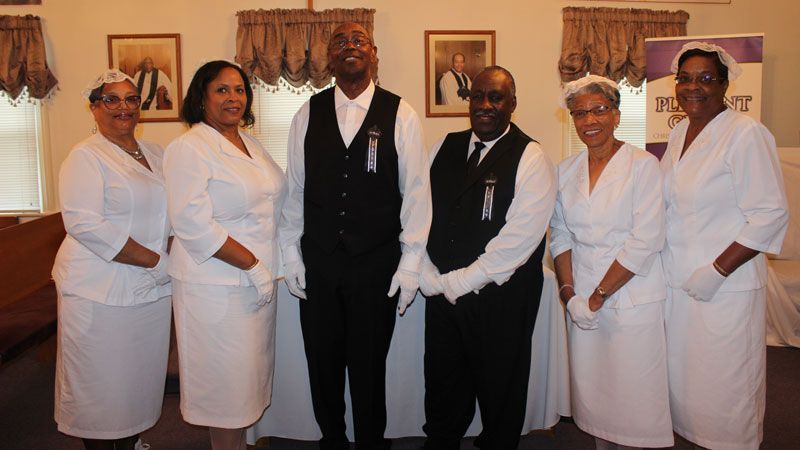 A group of people standing next to each other in a room.