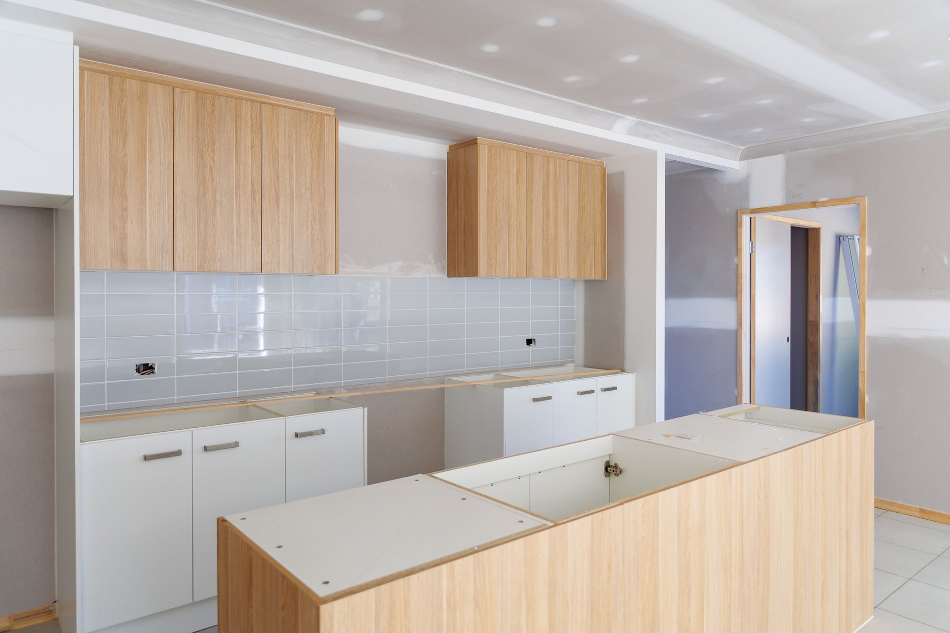 A kitchen under construction with wooden cabinets and a large island.