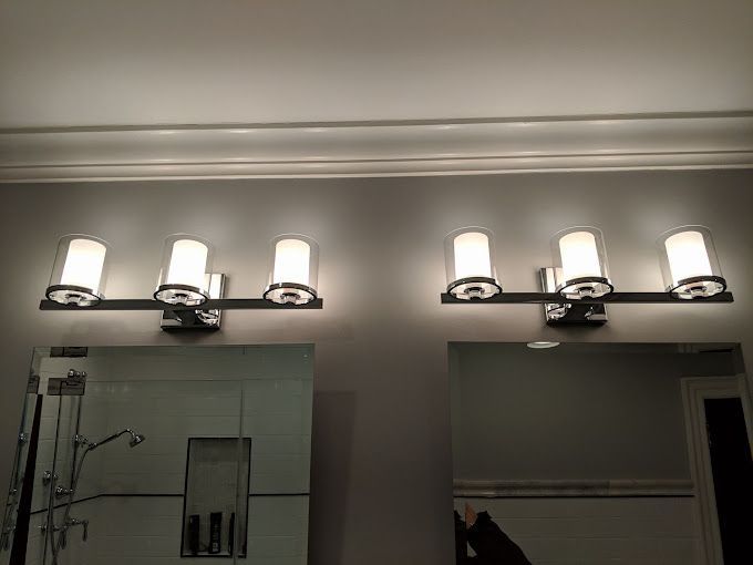 A bathroom with a vanity light and a mirror.