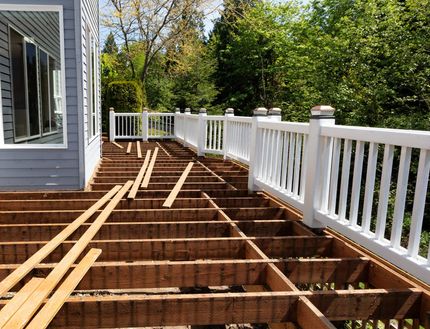 Deck under construction; wooden frame with white railing.