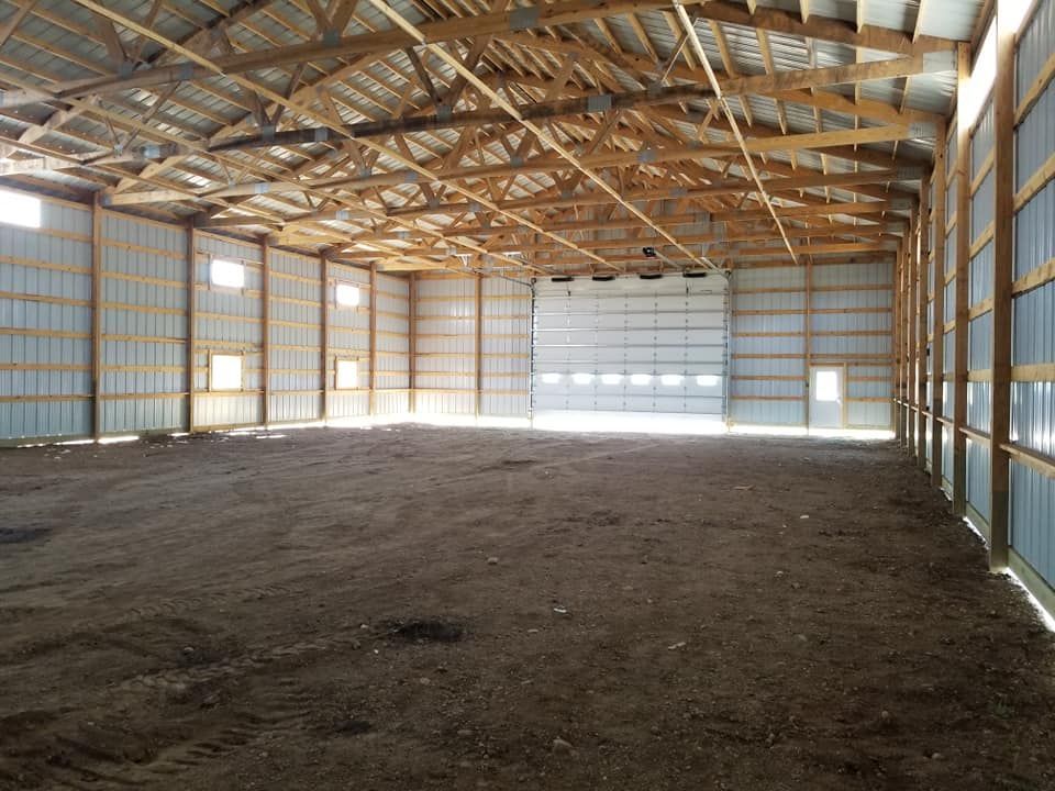 The inside of a large warehouse with a large garage door.