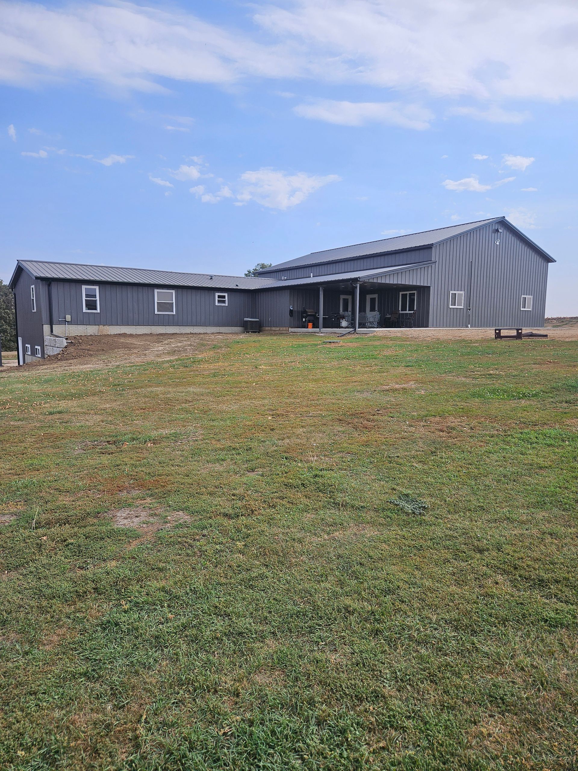 A large house is sitting in the middle of a grassy field.