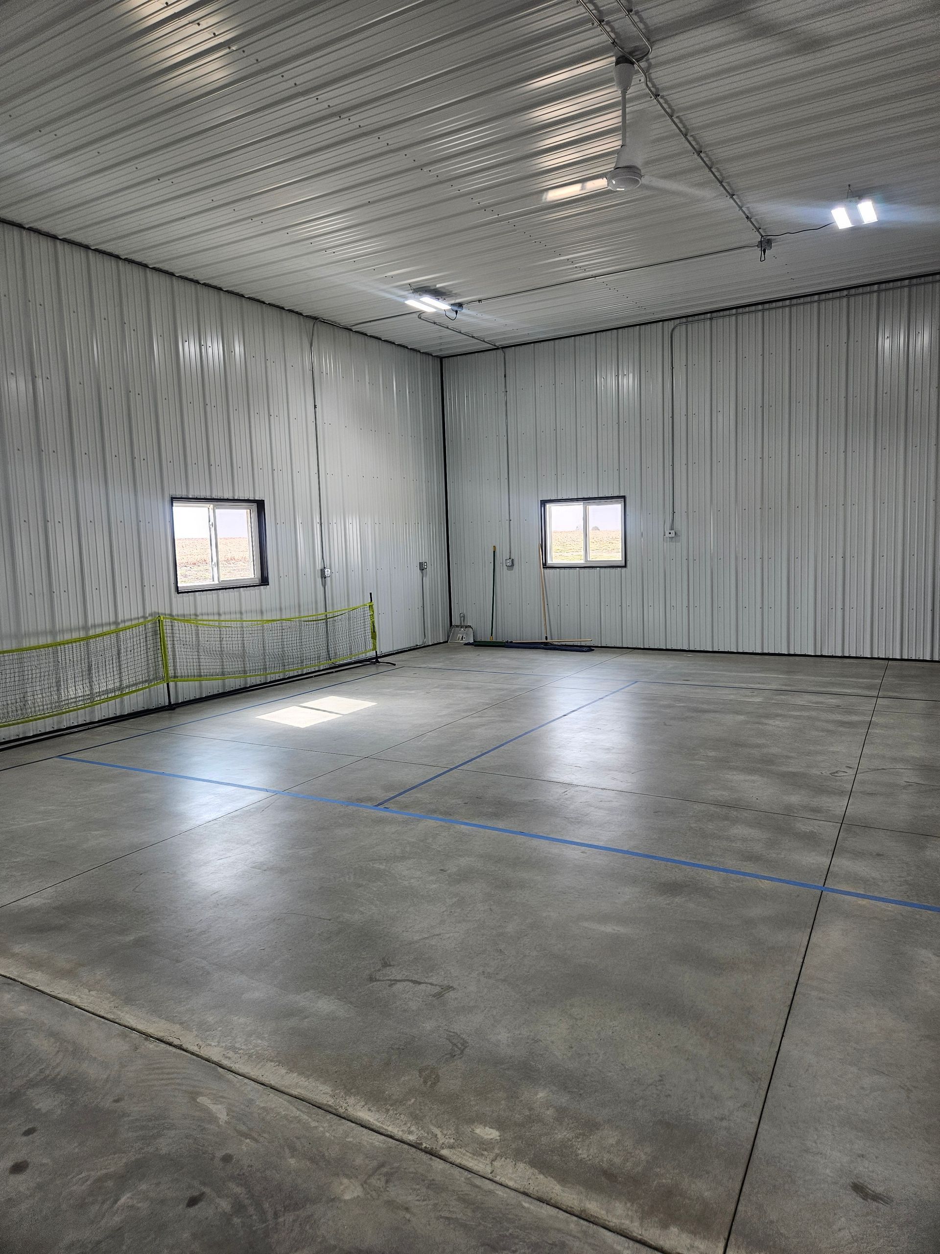 A large empty warehouse with a concrete floor and white walls.