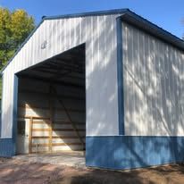 A white and blue metal building with a large door.