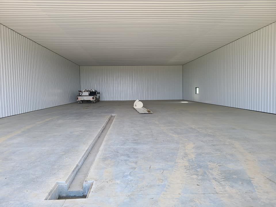 A large empty warehouse with a hole in the floor.