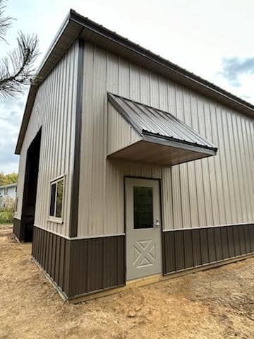 A large metal building with a door and awning.